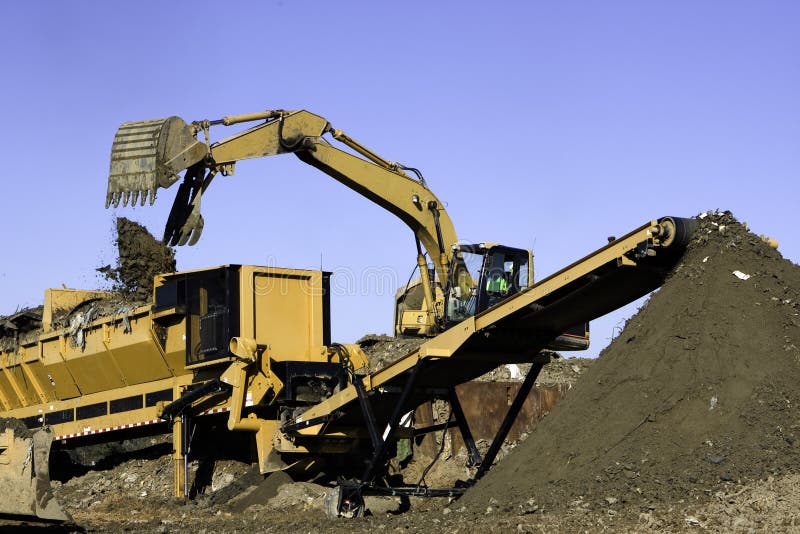 Frontend loader dumps landfill into a screener to separate solid waste from good soil which is transported by conveyor belt to preserve landfill space. Frontend loader dumps landfill into a screener to separate solid waste from good soil which is transported by conveyor belt to preserve landfill space.