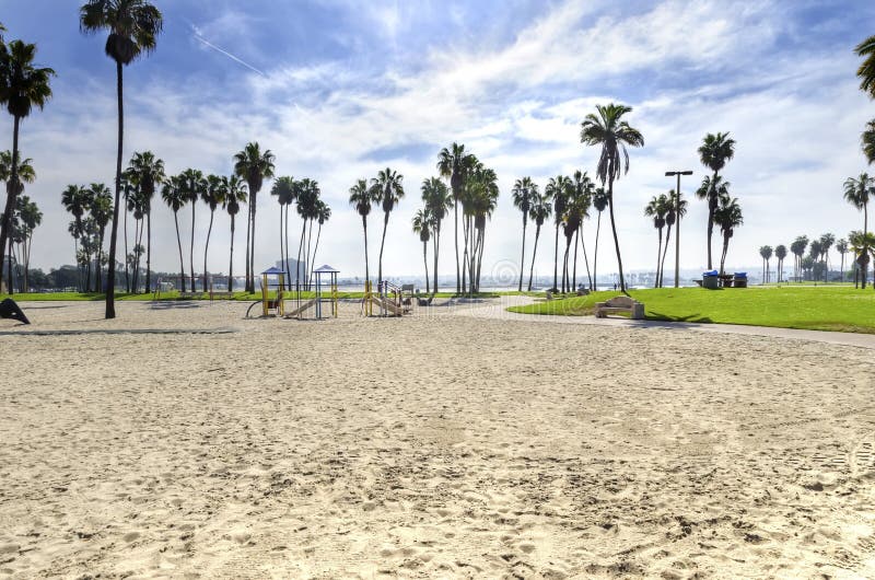 The Bonita cove park in southern Mission Bay over the Pacific beach in San Diego, California in the United States of America. A view of the golden sandy beach, palm trees, playground and clear sky. The Bonita cove park in southern Mission Bay over the Pacific beach in San Diego, California in the United States of America. A view of the golden sandy beach, palm trees, playground and clear sky.