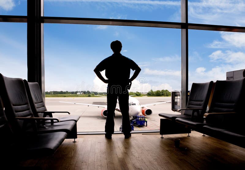 A male waits in a terminal at an airport. A male waits in a terminal at an airport