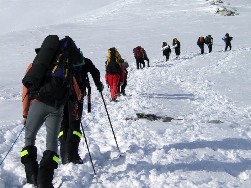 Mountaineers with backpacks climbing a snowy route. Mountaineers with backpacks climbing a snowy route.