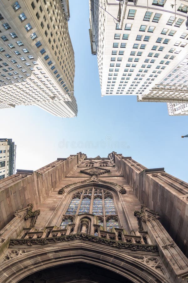 Aufwärts Weitwinkelansicht der Dreifaltigkeitskirche bei Broadway und des Wall Streets mit umgebenden Wolkenkratzern, Lower Manha stockfotografie Aufwärts Weitwinkelansicht der Dreifaltigkeitskirche bei Broadway und des Wall Streets mit umgebenden Wolkenkratzern, Lower Manha stockfotografie