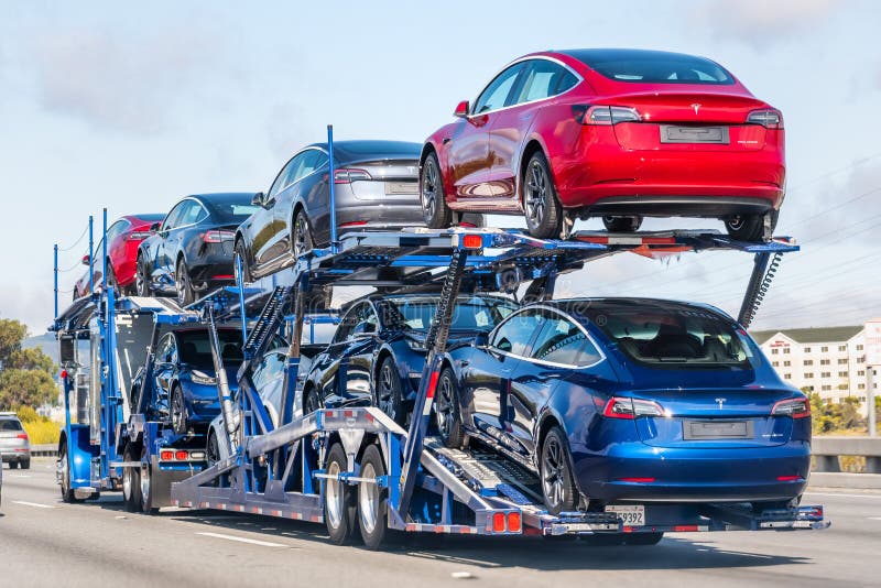 Aug 10, 2019 Burlingame / CA / USA - Car transporter carries Tesla Model 3 new vehicles on a freeway in San Francisco bay area