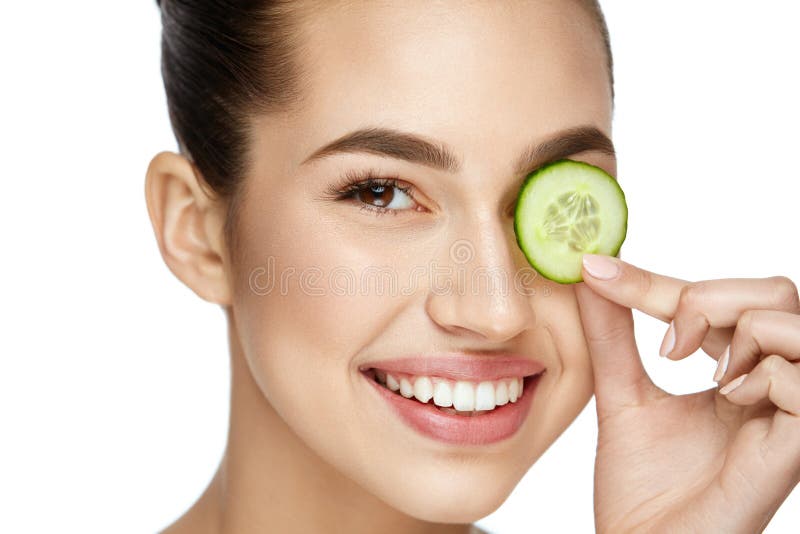 Augenhautpflege Frau mit natürlichem Make-up unter Verwendung der Gurke lizenzfreies stockfoto