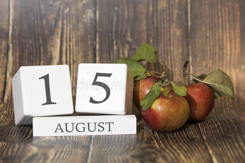 August 15. Day 15 of month. Calendar cube on wooden background with red apples, concept of business and an important event. Summer