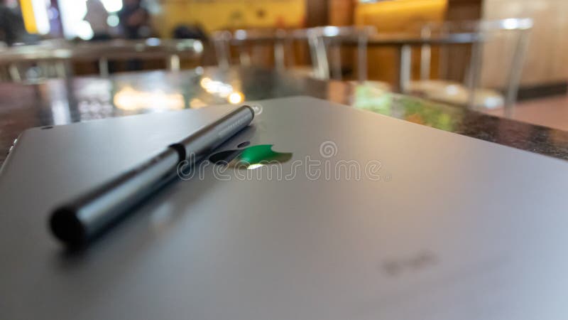 August 23, 2017, at Karnal, India - An Apple i pad screen down, a stylus placed over it and restaurant furniture with lighting.