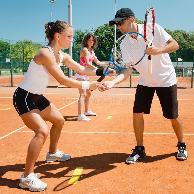 Tennis lessons - instructor working with students. Tennis lessons - instructor working with students