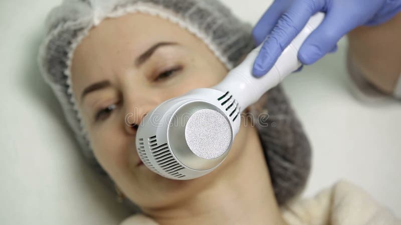 Aumento del labbro nel salone di bellezza il cosmetologo applica il freddo dopo la procedura per anestetico
