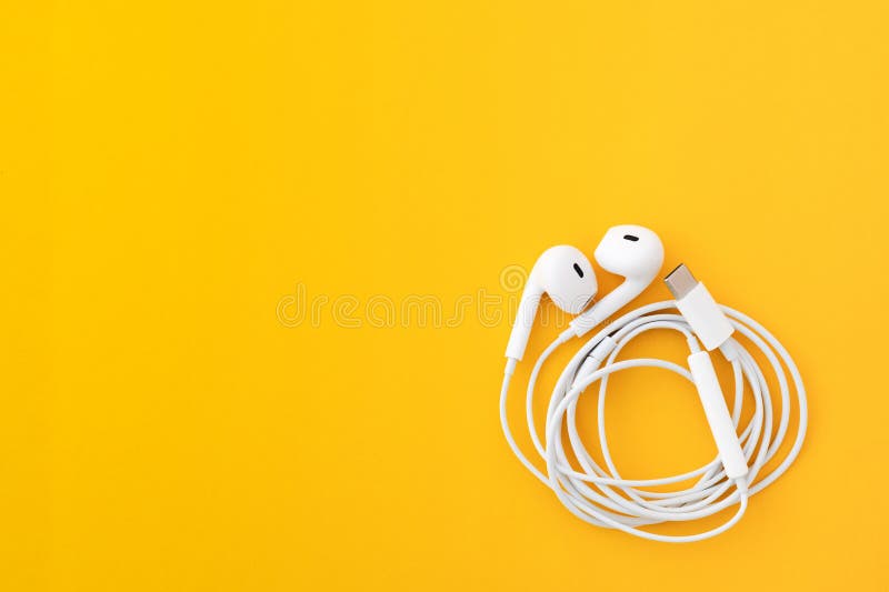 Auricolari bianchi isolati in giallo compreso lo spazio di copia immagini stock libere da diritti