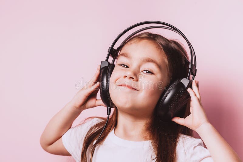 Auriculares que llevan de la m?sica de la ni?a que escuchan linda foto de archivo libre de regalías Auriculares que llevan de la m?sica de la ni?a que escuchan linda foto de archivo libre de regalías