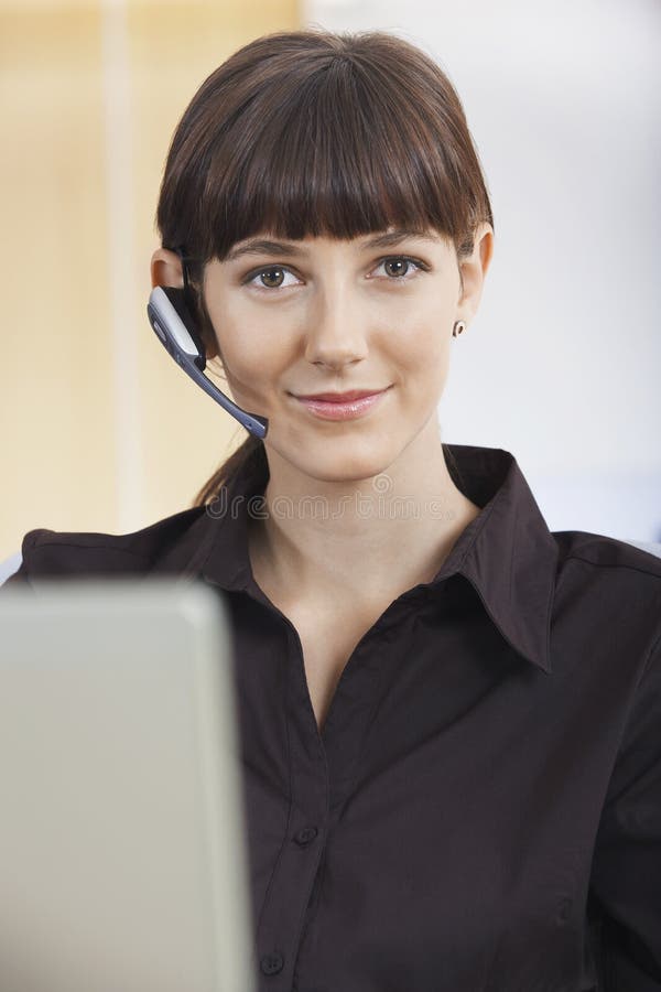 Auriculares vestindo do telefone do operador do serviço ao cliente imagem de stock royalty free Auriculares vestindo do telefone do operador do serviço ao cliente imagem de stock royalty free