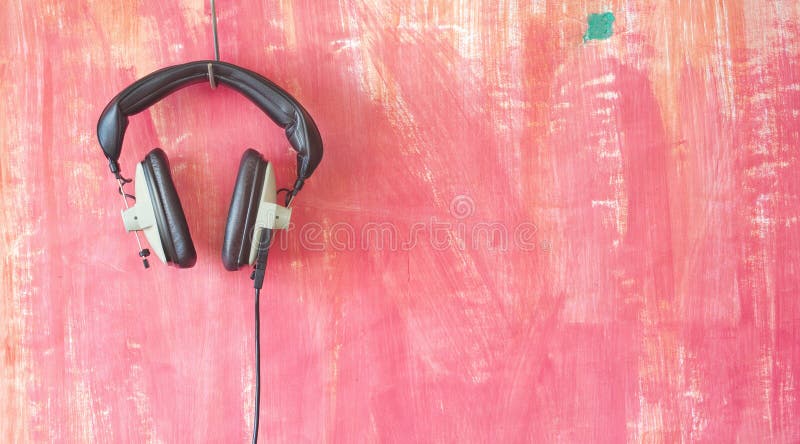 Auriculares vintage colgando en una pared poco rígida, escuchando, podcast, mu