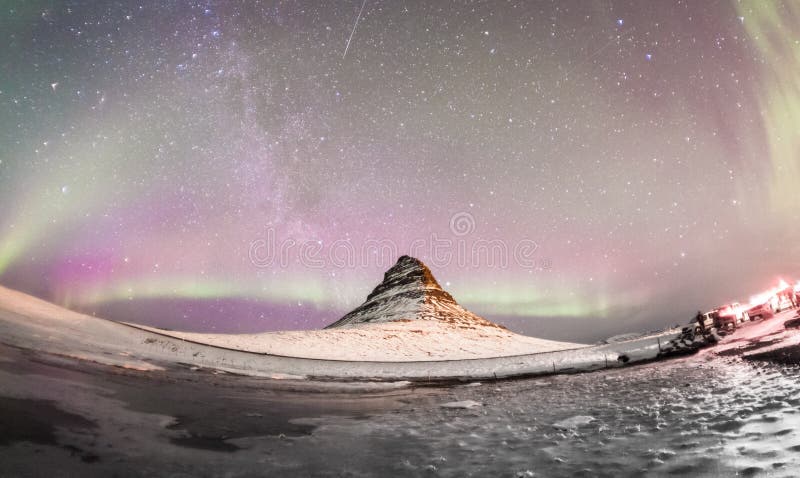 A aurora boreal e a Via Látea do inverno sobre Kirkjufell fotos de stock A aurora boreal e a Via Látea do inverno sobre Kirkjufell fotos de stock