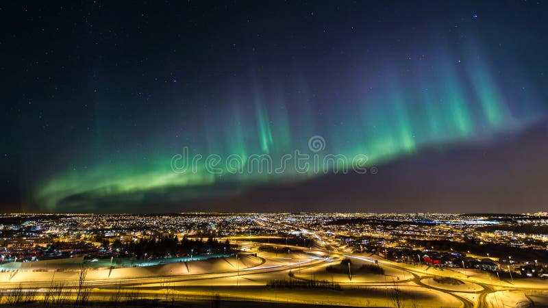 Aurora boreal sobre uma cidade