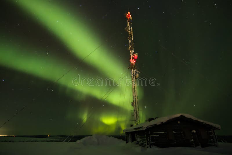 Aurora borealis au-dessus d'un cottage dans la distance sur l'horizon photo stock Aurora borealis au-dessus d'un cottage dans la distance sur l'horizon photo stock