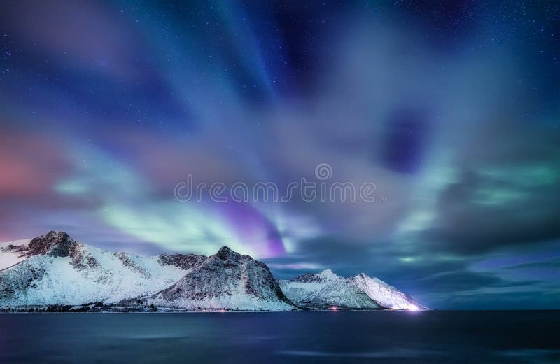 Aurora borealis på norrväg. Gröna nordliga ljus över berg och hav. vinterlandskap nattetid med aurora.