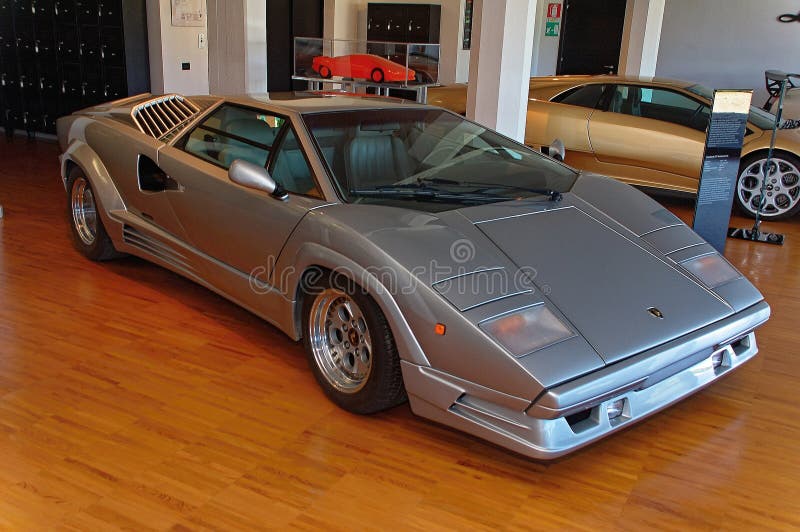 Named to honour the company's twenty-fifth anniversary in 1988, the 25th Anniversary Countach, although mechanically very similar to the 5000QV, sported considerable restyling done by Horacio Pagani. The Lamborghini Countach is a rear mid-engine, rear-wheel-drive sports car produced by the Italian automobile manufacturer Lamborghini from 1974 until 1990. It is one of the many exotic designs developed by Italian design house Bertone, which pioneered and popularized the sharply angled "Italian Wedge" shape. Named to honour the company's twenty-fifth anniversary in 1988, the 25th Anniversary Countach, although mechanically very similar to the 5000QV, sported considerable restyling done by Horacio Pagani. The Lamborghini Countach is a rear mid-engine, rear-wheel-drive sports car produced by the Italian automobile manufacturer Lamborghini from 1974 until 1990. It is one of the many exotic designs developed by Italian design house Bertone, which pioneered and popularized the sharply angled "Italian Wedge" shape.