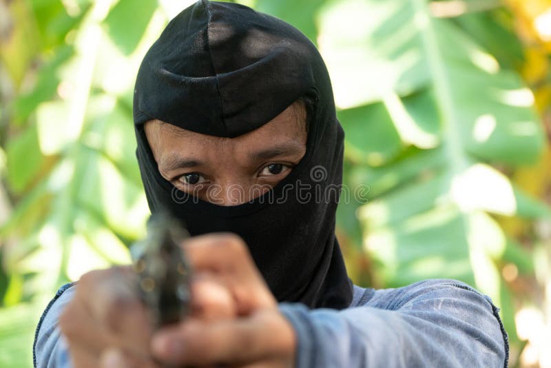 Ausgew?hlter Fokus von Verbrechenaugen R?uber in den schwarzen Sturmhaubezielen mit Gewehr lizenzfreie stockfotos Ausgew?hlter Fokus von Verbrechenaugen R?uber in den schwarzen Sturmhaubezielen mit Gewehr lizenzfreie stockfotos