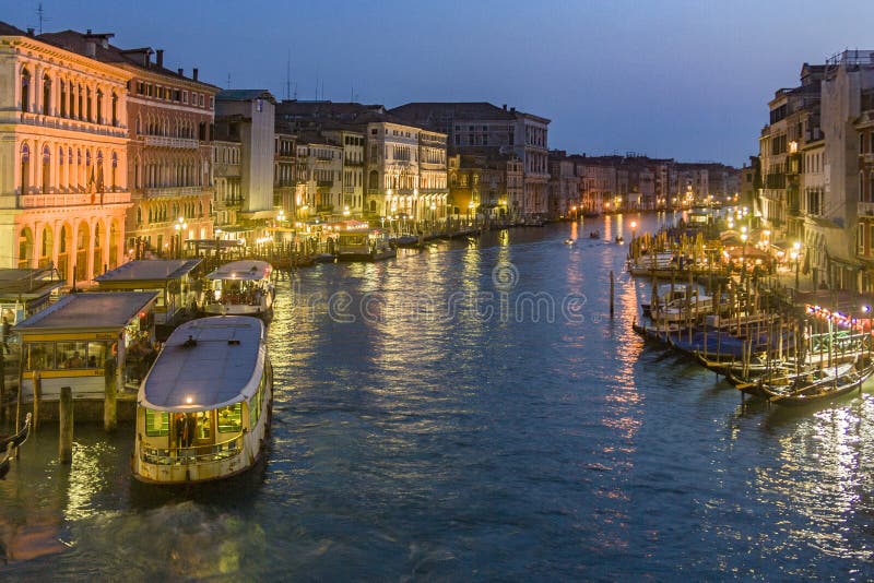 VENICE, ITALY - APRIL 7, 2007: view to Canale Grande by night in Venice, Italy. Canale Grande is 3,800 m long, 30Ã¢â‚¬â€œ90 m wide, with an average depth of five meters, rialto, adriatic, architecture, attraction, beautiful, boat, boats, building, cityscape, cloudy, color, culture, dramatic, dusk, european, evening, exterior, famous, gondola, historic, illuminated, italian, landmark, light, majestic, old, outdoors, reflections, scene, scenic, sky, sunset, tourism, tourist, touristic, transportation, travel, twilight, vaporetto, venetian, water. VENICE, ITALY - APRIL 7, 2007: view to Canale Grande by night in Venice, Italy. Canale Grande is 3,800 m long, 30Ã¢â‚¬â€œ90 m wide, with an average depth of five meters, rialto, adriatic, architecture, attraction, beautiful, boat, boats, building, cityscape, cloudy, color, culture, dramatic, dusk, european, evening, exterior, famous, gondola, historic, illuminated, italian, landmark, light, majestic, old, outdoors, reflections, scene, scenic, sky, sunset, tourism, tourist, touristic, transportation, travel, twilight, vaporetto, venetian, water