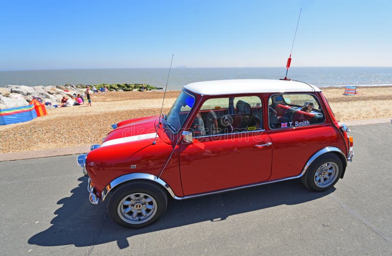 Austin Mini Car rojo clásico parqueado en la 'promenade' de la orilla del mar imagen de archivo Austin Mini Car rojo clásico parqueado en la 'promenade' de la orilla del mar imagen de archivo