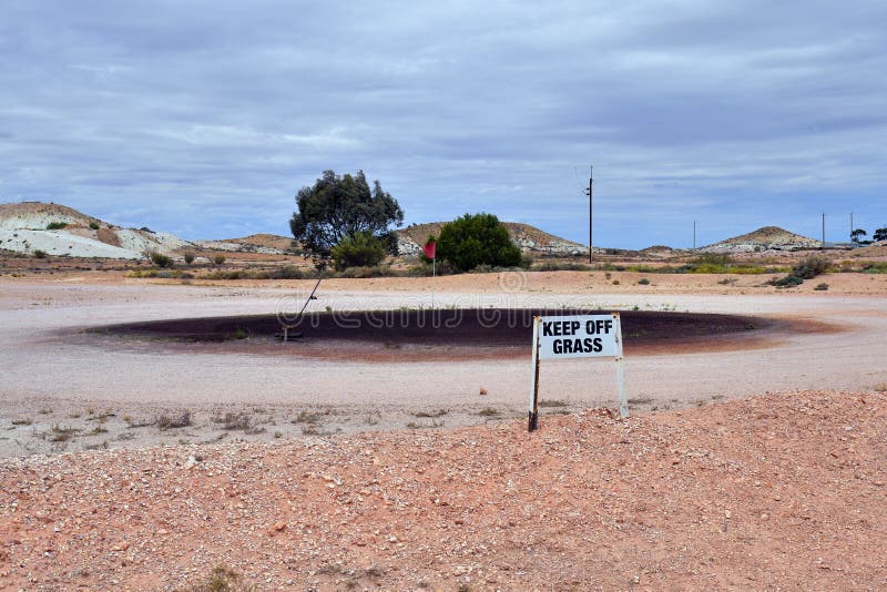 Australia, Coober Pedy, homorous sign on grass less golf court. Australia, Coober Pedy, homorous sign on grass less golf court