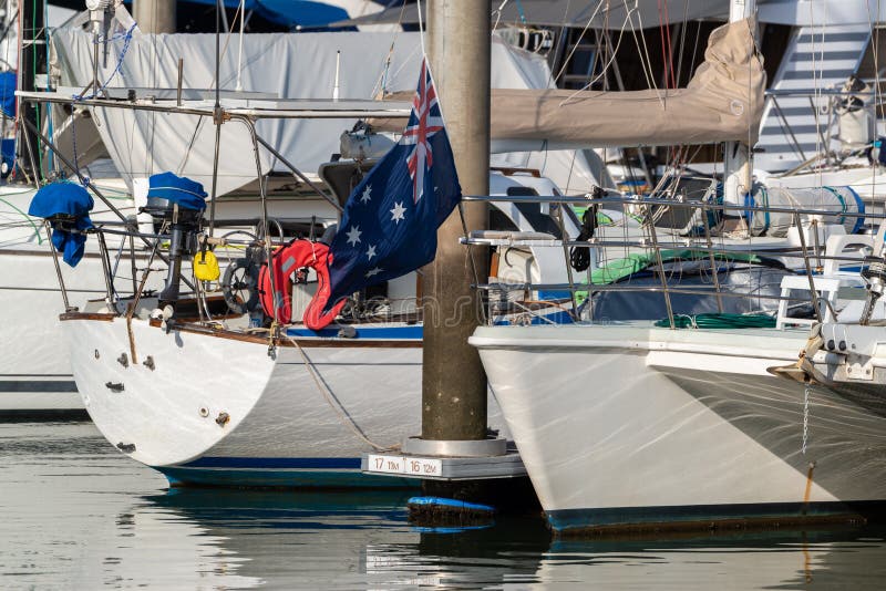 Australian Flag Flying from the Bow of a Yacht in a Marina Stock Photo