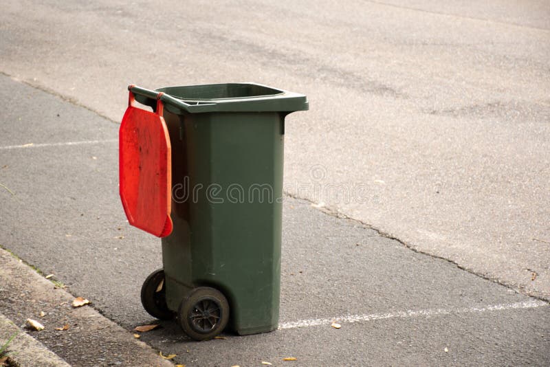 Australian garbage wheelie bin with red lid