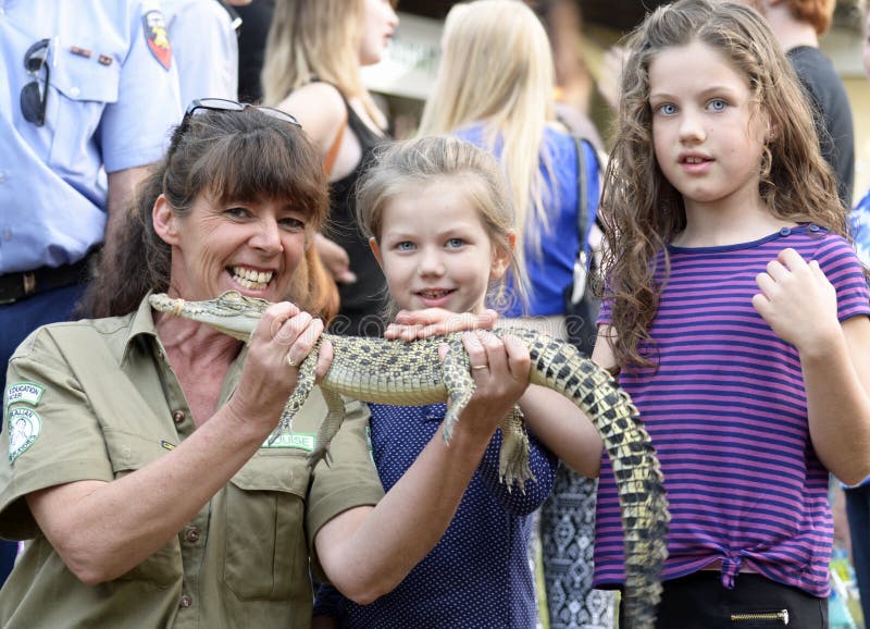 An Australian wildlife woman park ranger enjoying herself , teaching children about our wonderful native animals, crocodiles and wildlife species and how to care for them. Here she had a baby crocodile which was causing great interest from the passing children. Photograph taken at Boonah Annual Show, Scenic Rim , Queensland, Australia. This photograph is for editorial content only. An Australian wildlife woman park ranger enjoying herself , teaching children about our wonderful native animals, crocodiles and wildlife species and how to care for them. Here she had a baby crocodile which was causing great interest from the passing children. Photograph taken at Boonah Annual Show, Scenic Rim , Queensland, Australia. This photograph is for editorial content only.