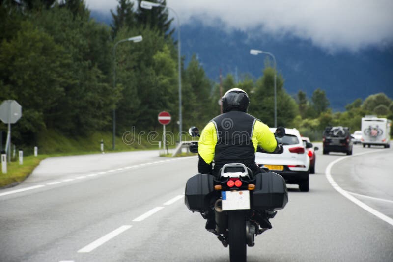 Austriaco y gente de los viajeros que conduce el coche y que monta la moto en el camino fotos de archivo libres de regalías