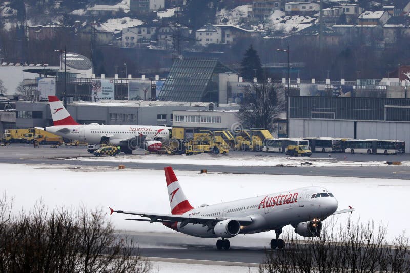 Austrian Airlines nivålandning på den snöig landningsbanan, Innsbruck flygplats arkivbild