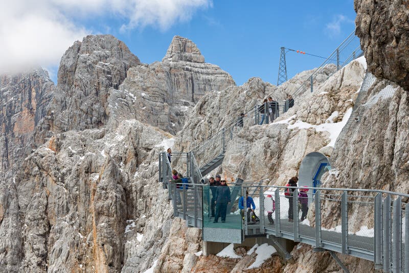 Austrian Dachstein Mountains with hikers passing a skywalk rope bridge