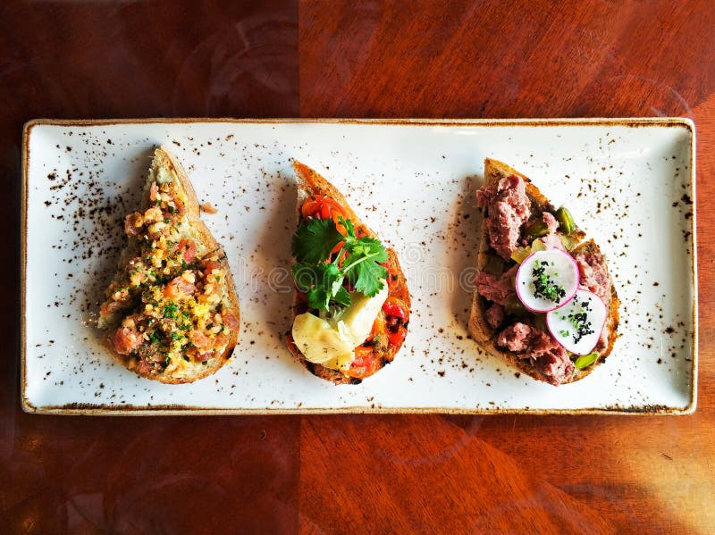 Autentiska traditionella spanska tapas ställde in på trätabellen för lunch, bästa sikt Val av bruschettaen på vresigt bröd arkivfoto Autentiska traditionella spanska tapas ställde in på trätabellen för lunch, bästa sikt Val av bruschettaen på vresigt bröd arkivfoto