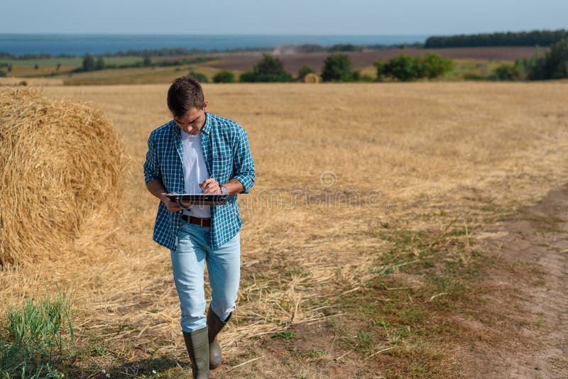 Authentic front portrait of young man farmer agronomist in the haystack
