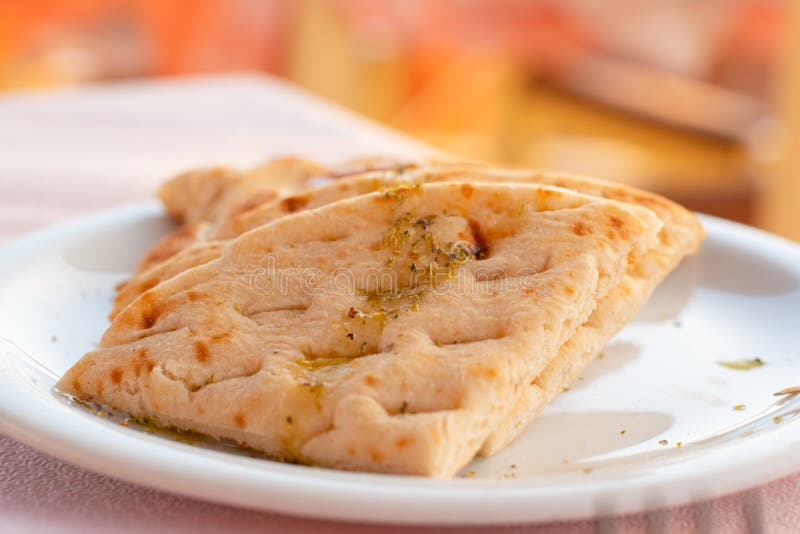 An authentic Greek pitta bread served in a restaurant. Authentic Mediterranean pitta bread served in a romantic Greek restaurant, on the island of Santorini stock images An authentic Greek pitta bread served in a restaurant. Authentic Mediterranean pitta bread served in a romantic Greek restaurant, on the island of Santorini stock images
