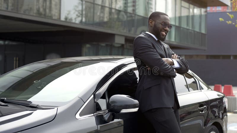 Autista personale della persona importante sull'automobile elegante, amante e godente del suo lavoro fotografie stock libere da diritti Autista personale della persona importante sull'automobile elegante, amante e godente del suo lavoro fotografie stock libere da diritti