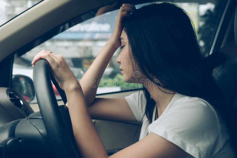 Autista sollecitato della donna che si siede dopo in automobile che ha fermata di emicrania fotografia stock libera da diritti Autista sollecitato della donna che si siede dopo in automobile che ha fermata di emicrania fotografia stock libera da diritti