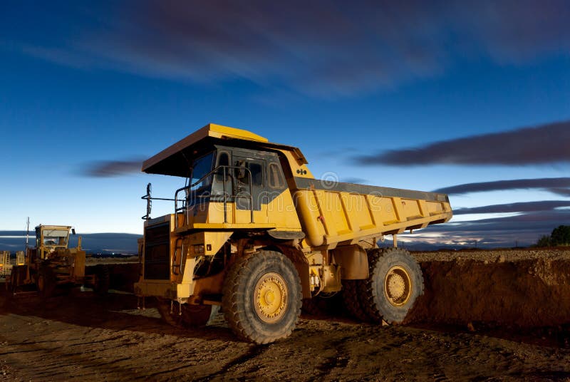 Huge auto-dump yellow mining truck night shot and excavator. Huge auto-dump yellow mining truck night shot and excavator