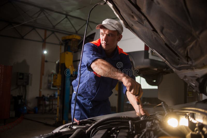 Auto het mechanische werken in de autoreparatiedienst Het herstellen van auto het gebruiken stock afbeelding Auto het mechanische werken in de autoreparatiedienst Het herstellen van auto het gebruiken stock afbeelding