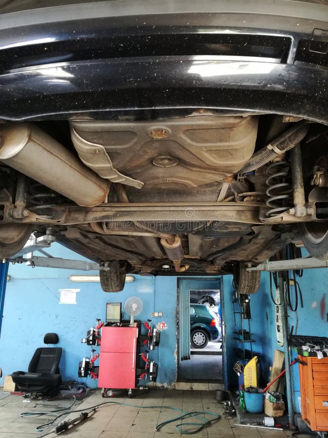 Auto im Einsatz, angehoben auf Hochleistungshydraulik-Wagenheber Arbeitskräfte sind verantwortlich für Wagenpflege und Reparatur lizenzfreies stockfoto Auto im Einsatz, angehoben auf Hochleistungshydraulik-Wagenheber Arbeitskräfte sind verantwortlich für Wagenpflege und Reparatur lizenzfreies stockfoto