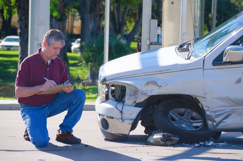 Auto insurance adjuster inspecting accident claim