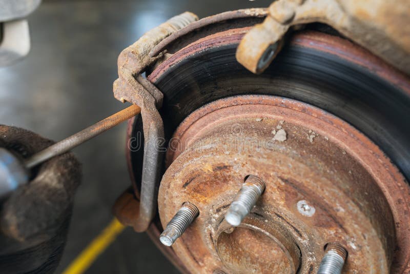 An Auto Mechanic Grinds Off Rust on the Brake Discs before Replacing
