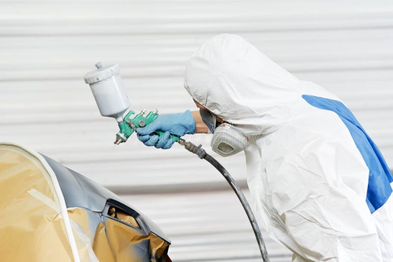 Auto mechanic painting car bumper royalty free stock photography