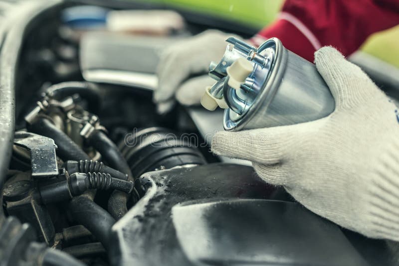 An Auto Mechanic Replaces a Car`s Fuel Filter. Stock Photo Image of