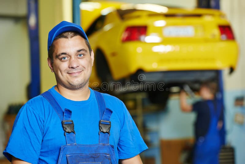 Repairman auto mechanic Portrait in car auto repair or maintenance shop service station. Repairman auto mechanic Portrait in car auto repair or maintenance shop service station