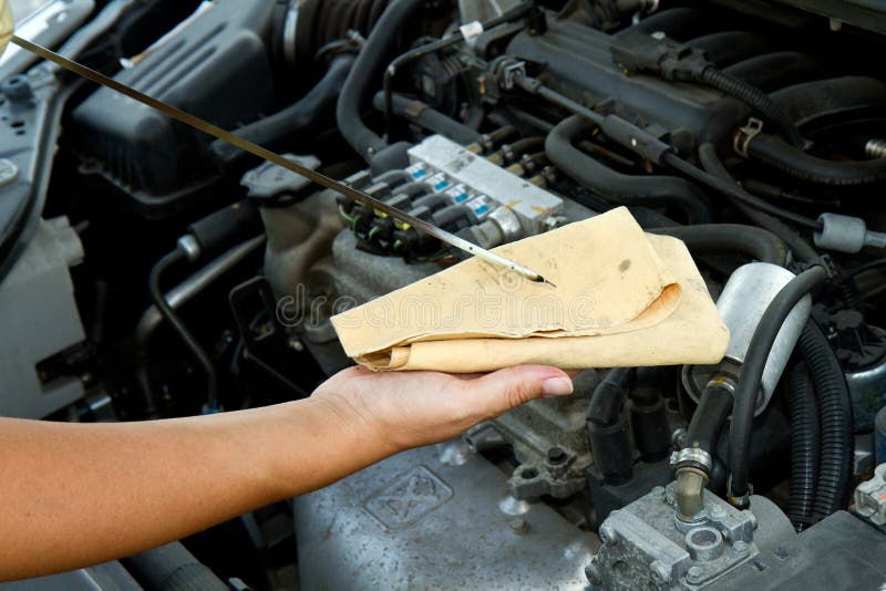 An Auto mechanic checking oil. An Auto mechanic checking oil