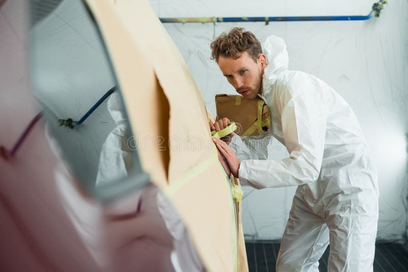 Auto Painter Masking Car Body with Tape and Paper before Repaint