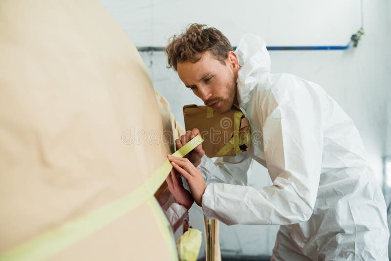 Auto Painter Masking Car Body with Tape and Paper before Repaint