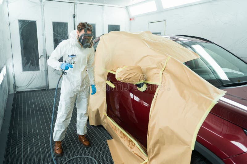 Auto Painter with Spray Gun in Car Painting Booth. Stock Photo Image