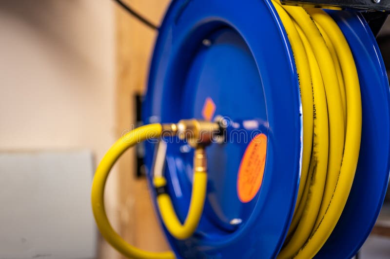 Auto-rewinding Air Hose Reel with Coiled Tubing Mounted on a Wall in a Shop  Stock Photo - Image of compressed, hydraulic: 225178436
