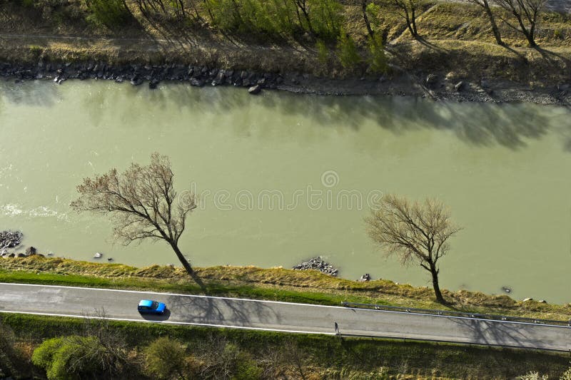 View from above on a car on a country road by a river, Rhone river near Martigny, Valais, Switzerland. View from above on a car on a country road by a river, Rhone river near Martigny, Valais, Switzerland