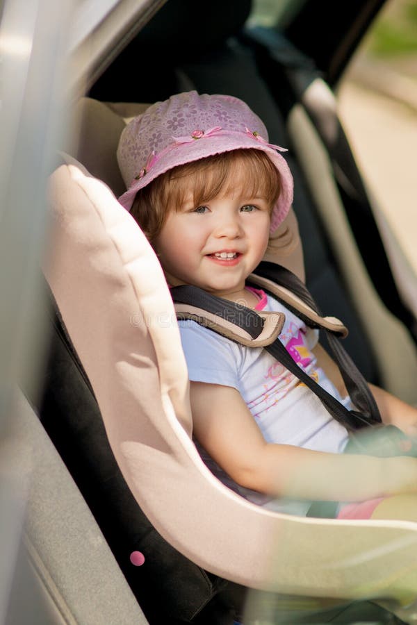 Little girl in safety auto seat with smile siting. Little girl in safety auto seat with smile siting